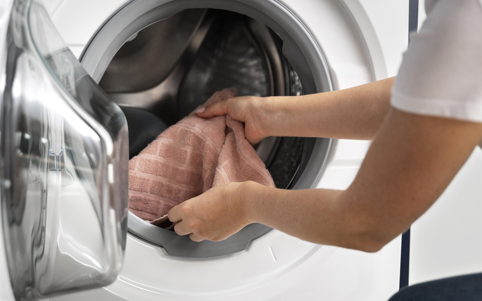 Woman taking clothes from a washing machine